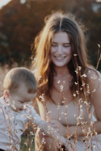 a woman and her son in a field of tall grass