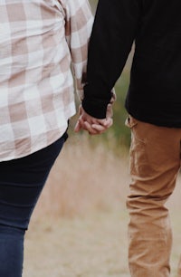 a man and woman holding hands in a field