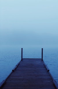 a wooden dock on a foggy lake