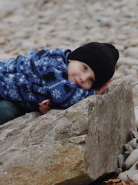 a child laying on a rock