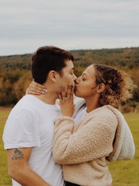 a man and woman kissing in a field