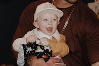 a man holding a baby with a hat on