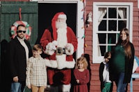 santa claus with a family in front of a house