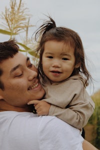 a man holding a little girl in his arms