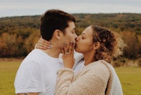 a man and woman kissing in a field