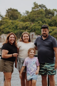 a family posing for a photo near a body of water