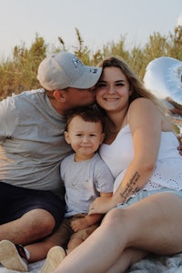 a family sits on the beach with balloons