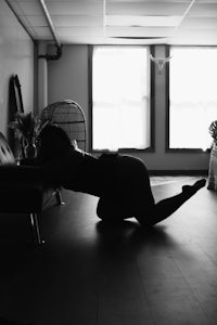 a black and white photo of a woman laying on the floor