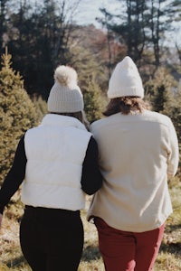 two women walking through a christmas tree farm