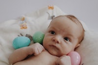 a baby laying on a blanket with colorful easter eggs