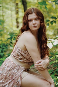 a woman in a dress posing in the woods