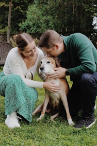 a man and woman petting a dog