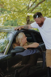 a woman leaning into a car