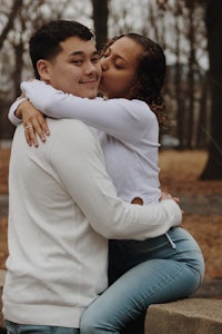 a man and woman hugging in a park