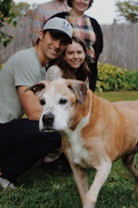 a group of people posing with a dog