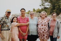 a group of people posing for a photo on the beach