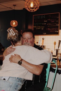 a man is hugging a woman in a bar