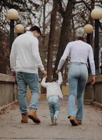 a family walking down a path with a small child