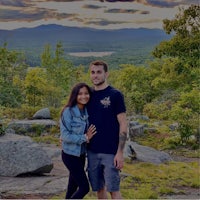 a man and woman posing for a photo on top of a mountain