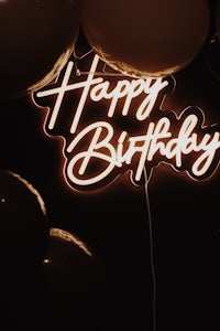 happy birthday neon sign with balloons