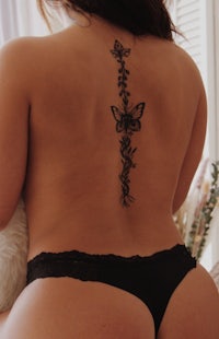 the back of a woman with a butterfly tattoo on her back