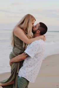 a couple kissing on the beach during their engagement session