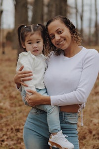 a woman holding her daughter in the woods