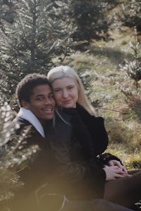 a couple posing in front of a christmas tree